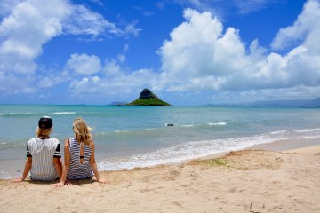 women sitting on beach in O'ahu